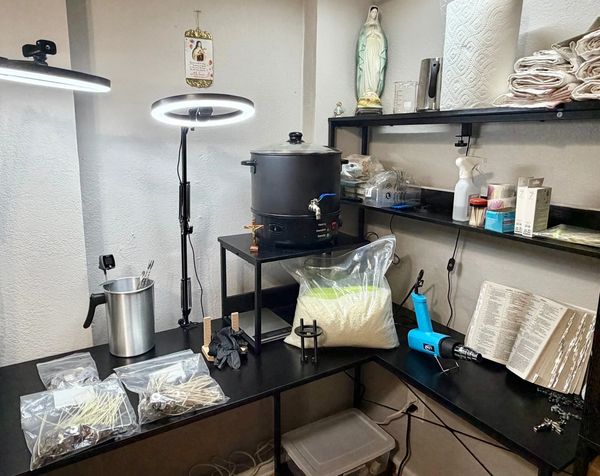 Workshop with tools, religious items, and materials for crafting or candle making.