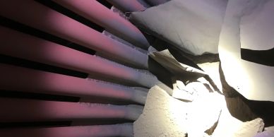 Broken white ceramic pieces near pink and black pipes.