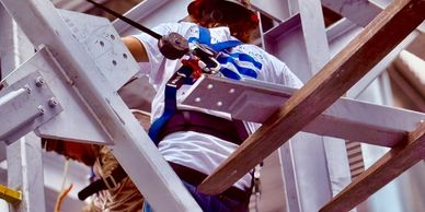 Construction worker tied with safety harness at height.