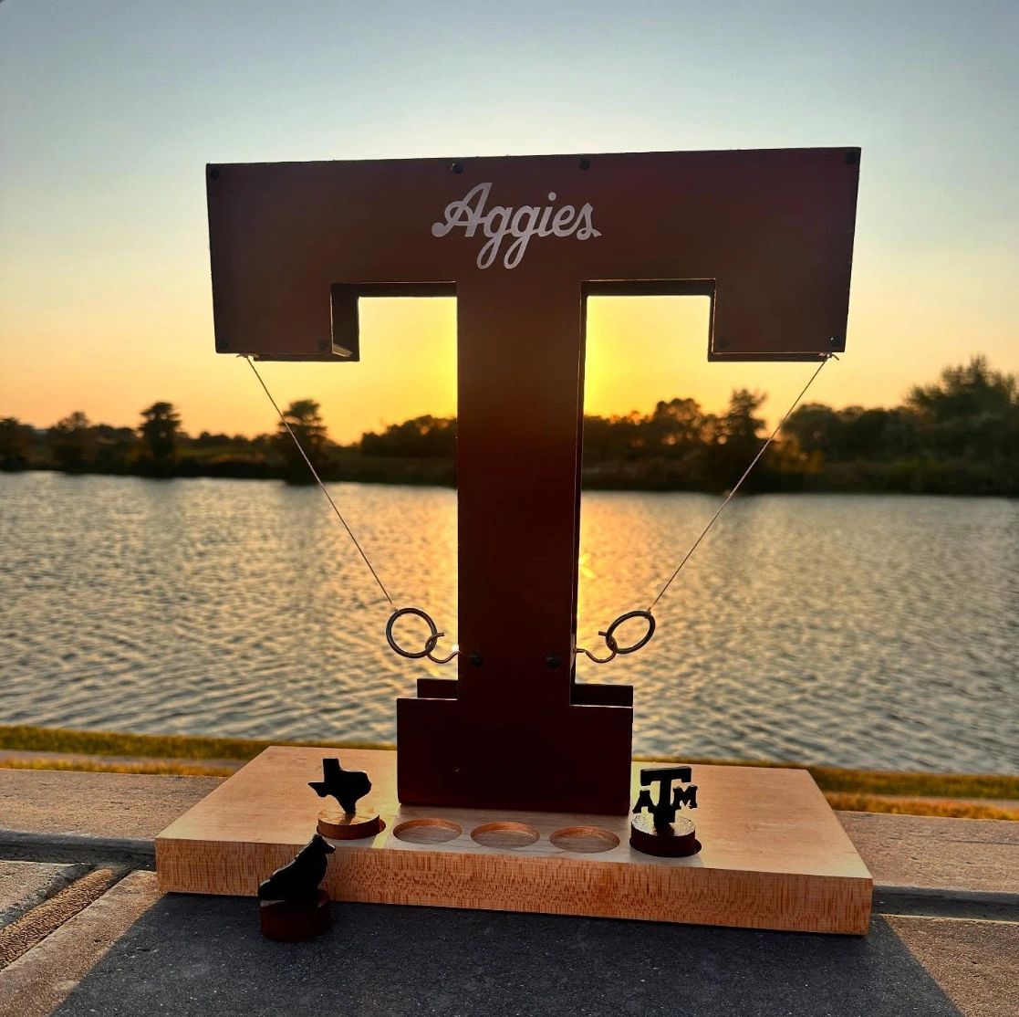 Texas A&M Aggies-themed ring toss game at sunset by the water.