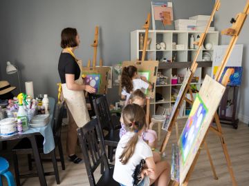 Art class with children painting on easels.