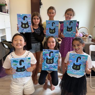 Children proudly showing their cat paintings.