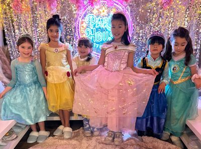kids dressed as princesses enjoying the fashion fiesta party with sparkly backdrop and fun activitiy