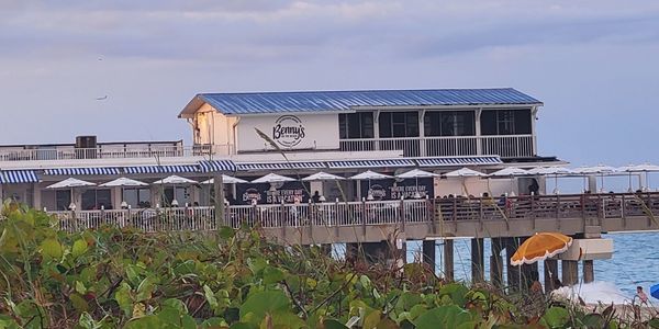 Luxury cabana setup near Lake Worth Pier with umbrellas and chairs. Bennys on the Beach