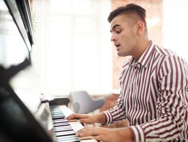 Male student sings and plays piano at St Louis private music studio