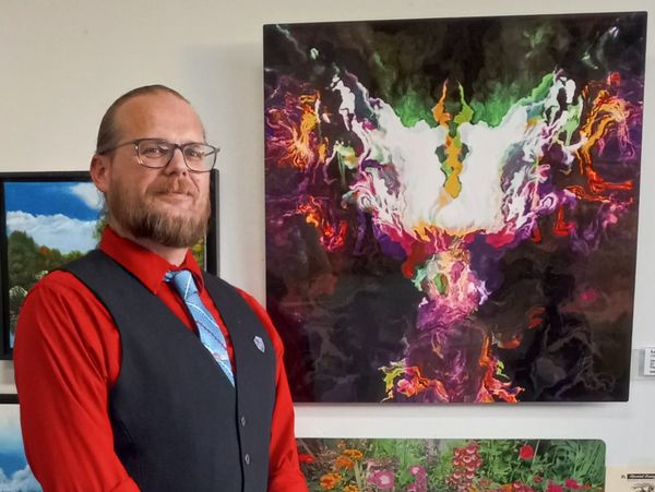 Leroy Binks posing next to his abstract artwork at a recent gallery show.