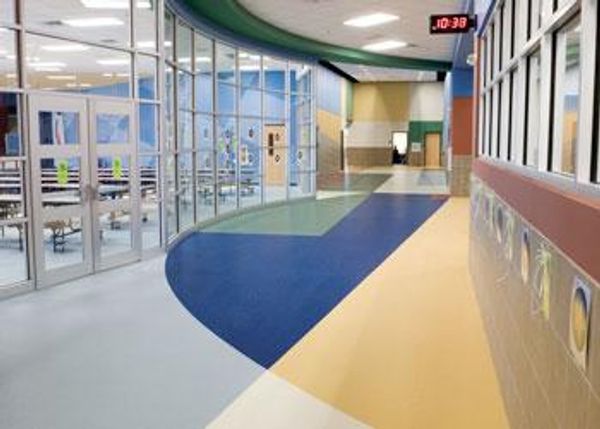 Commercial school hallway with multicolored vinyl flooring.