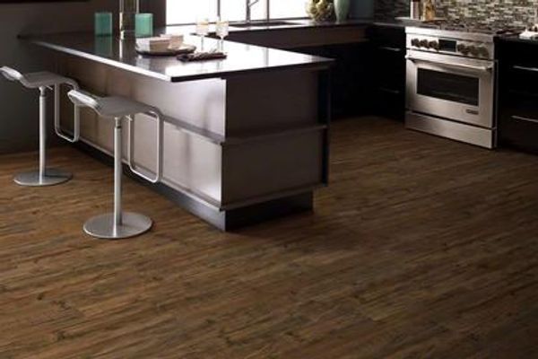 Kitchen with dark mahogany-look vinyl plank floor.