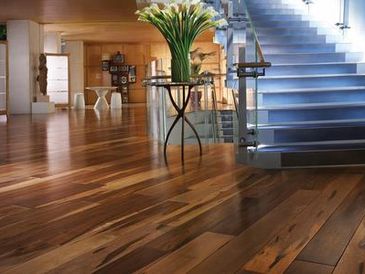 Entryway with shiny hardwood floor and stairs.