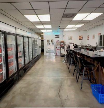 Inside view of a meat shop with freezers and counter seating.
