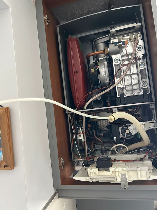 Open boiler unit showing internal components and wiring.