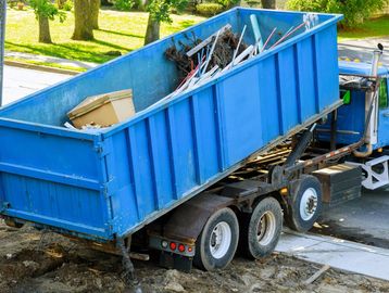 Waste materials being loaded and removed by a truck for disposal / recycling