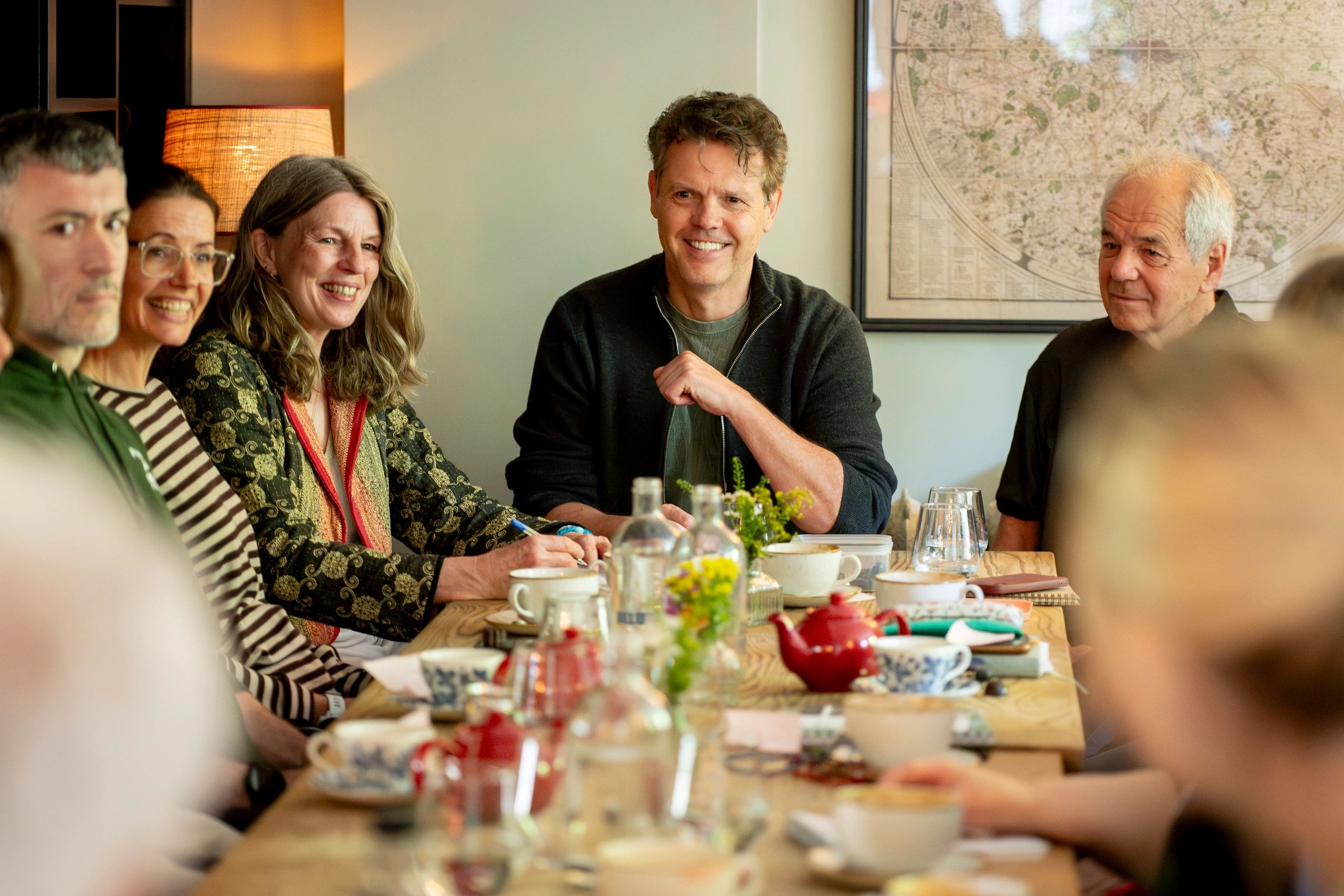 A diverse group of health and wellbeing practitioners in relaxed professional conversation