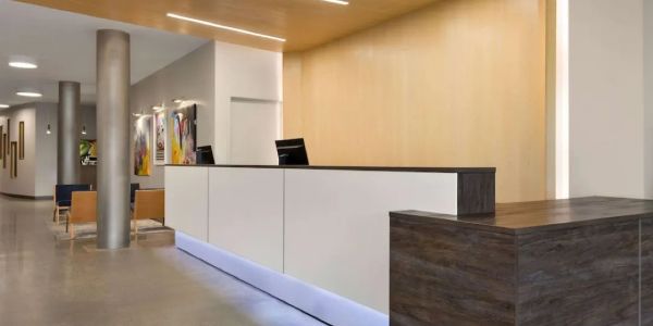 Modern reception area painted with wooden and white counters.