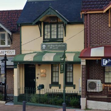 A small, quaint building with a green and beige striped awning and signage.