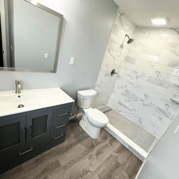 Remodeled bathroom with shower, tile work, vanity, mirror and flooring
