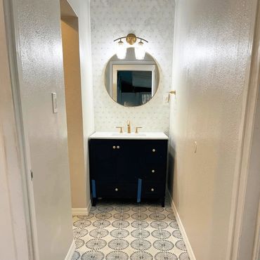 Remodeled bathroom with new floor, vanity, mirror and light fixtures