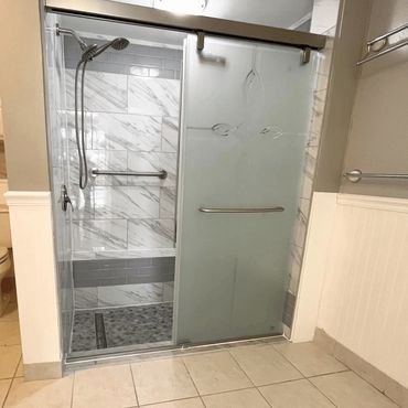 Renovated shower with glass doors, tile work and fixtures