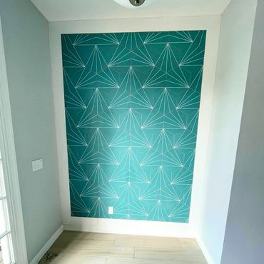 Blue green wall with a design painted on it