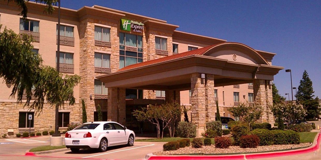 Holiday Inn Express hotel entrance with a white car parked.