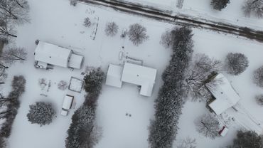 Aerial view of snow-covered houses and trees in winter.