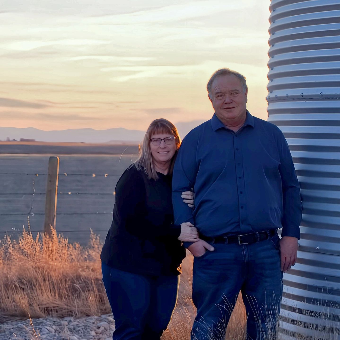 Llew and Carole Jones by the grain bins on the family ranch near Conrad