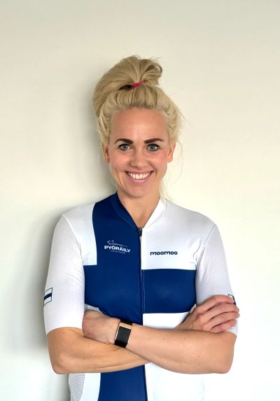 Smiling woman in a blue and white cycling jersey.