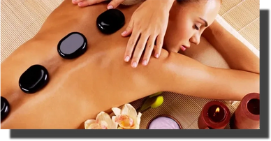 Massage therapist placing Hot Stone / Heating Pad on client.