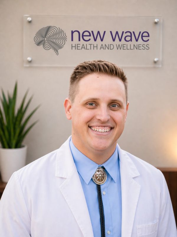 Smiling healthcare professional in a white coat at New Wave Health and Wellness.
