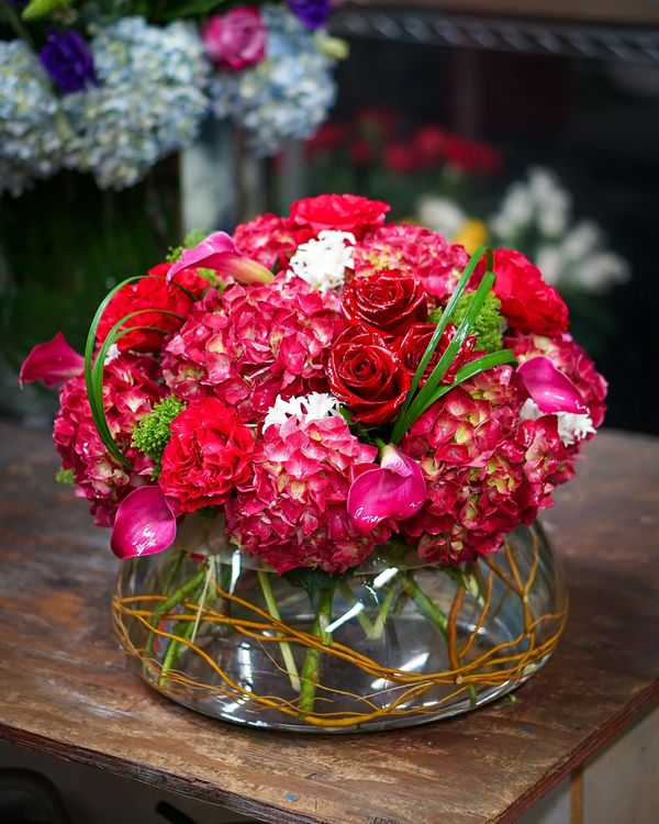 A beautiful floral centerpiece in red from Nature's Bouquet. Your premium florist in Wellington FL
