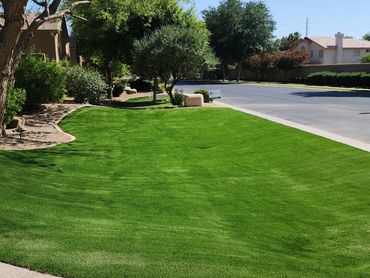 A sunny and lush manicured front yard artificial turf installation by Tempe Turf Installers.