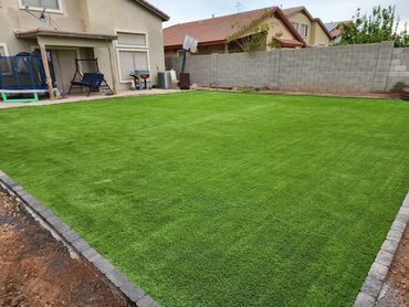 A brown house with an artificial turff lawn installed by Tempe Turf Installers on a sunny day.