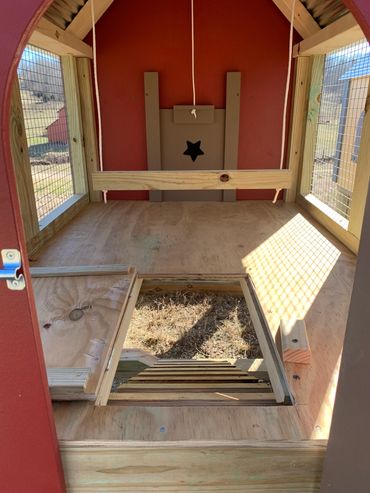 Inside the run area, there is a trap door that opens and closes to allow chickens access to a ramp.