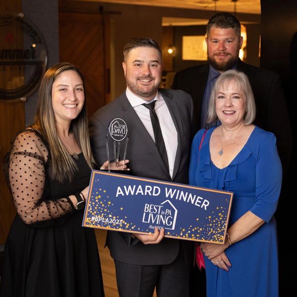 Group celebrating an award win with smiles and a trophy.