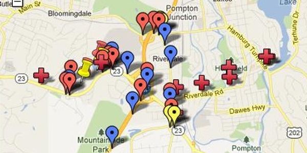 Map with various colored pins and red crosses.