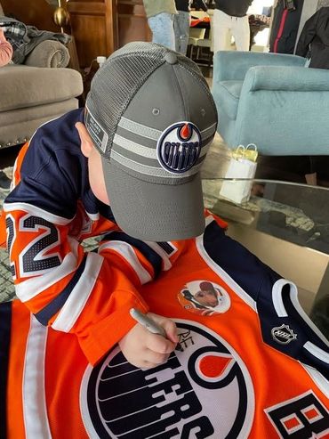 Ben Signing his jersey at Ashif and Zainul Mawji's home - Ben Stelter Foundation