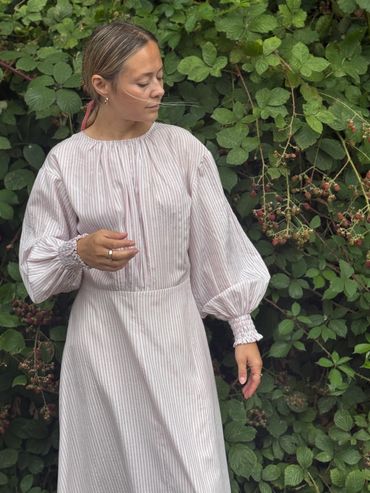 front of the dress showing gathered details on neck, waist and smocked sleeves