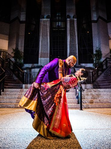 Couple in traditional attire sharing a romantic dance pose in an elegant indoor setting.
