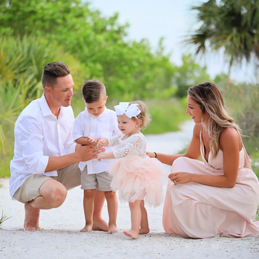 Family of four enjoying a moment outdoors on a sandy path.