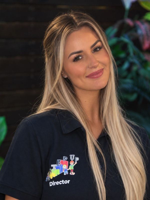 Smiling woman with long blonde hair wearing a black shirt.
