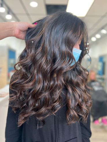 Wavy, shiny brown hair styled beautifully at a salon.