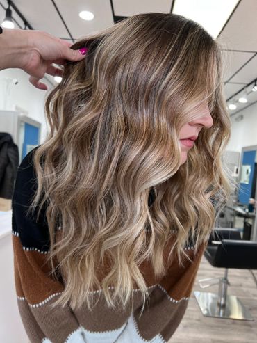 Wavy blonde hair with highlights styled in a salon.