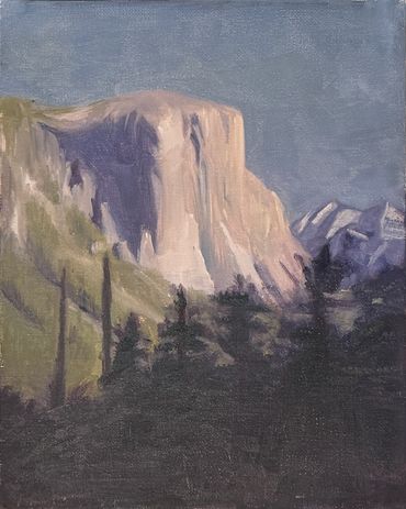 A rocky mountain with a flat top rises to the left, surrounded by green hills, mountains in the back