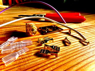 Various electrical connectors, wires, and screws on a wooden surface.