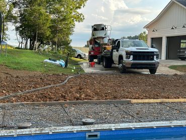 Concrete pouring setup at a residential driveway under construction.
