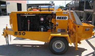 Yellow REED B50 construction machine with exposed engine and single wheel.