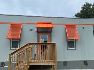 Bahama shutters over residential tower windows metal awnings