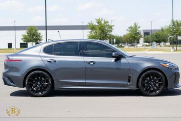 Sleek gray sports sedan with black rims parked outdoors.