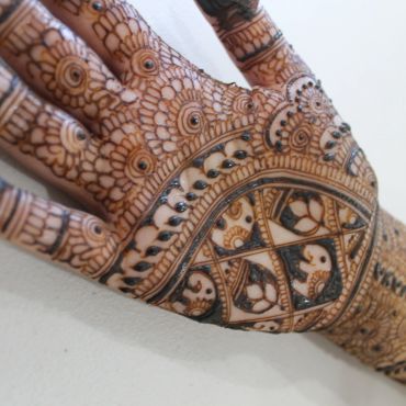 Intricate henna design featuring elephants on a hand.