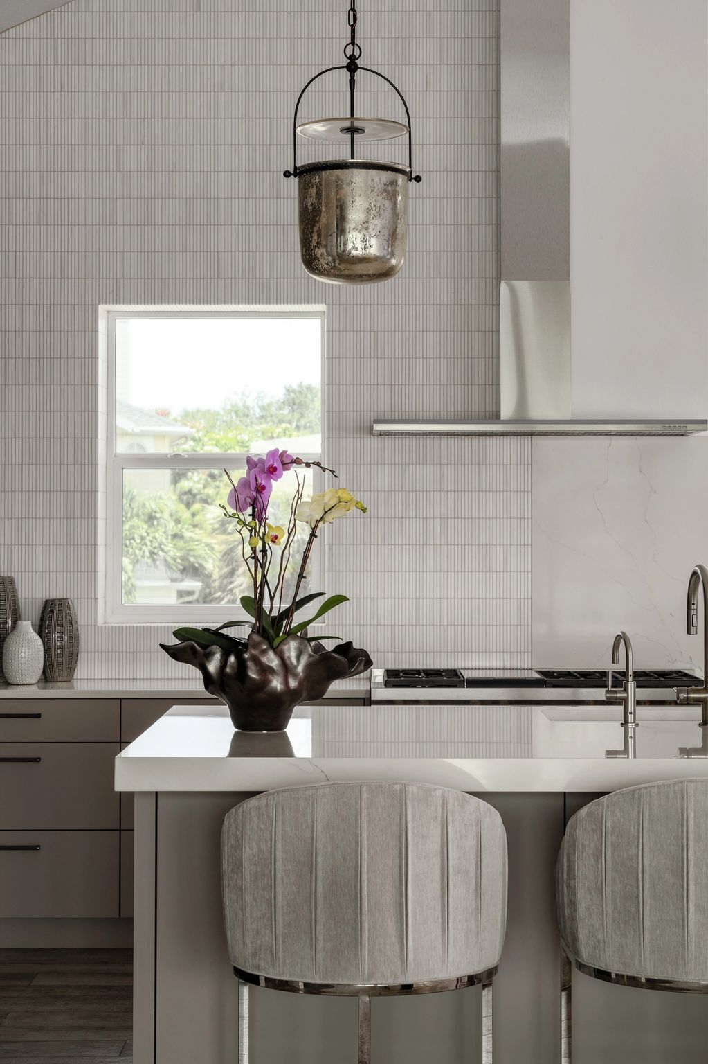 Kitchen with pendants and marble mosaic backsplash